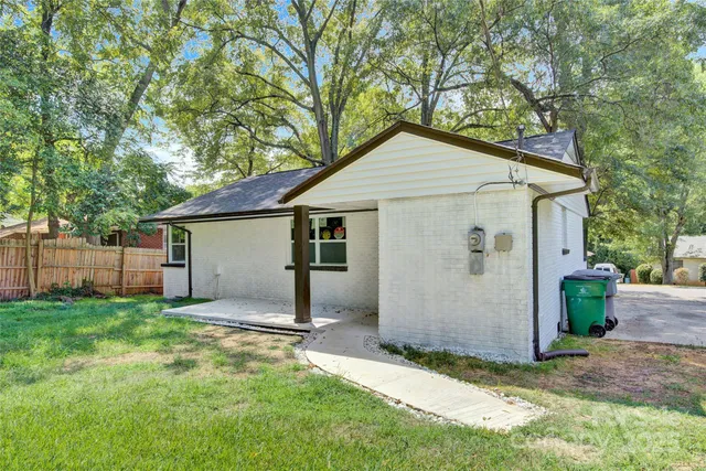 a view of a house with a yard and fence