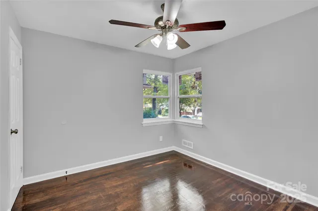 an empty room with a window and a fan