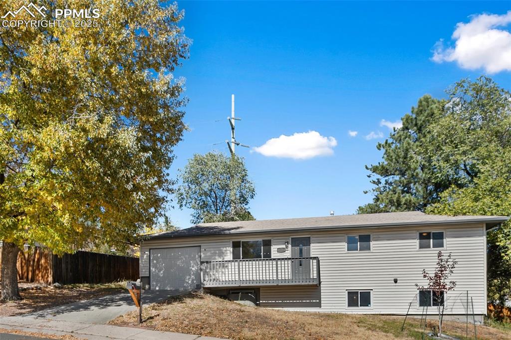 2518 Royalty Court Colorado Springs, CO 80904 - Photo 11 of 47 a view of a white house with a big yard and large tree