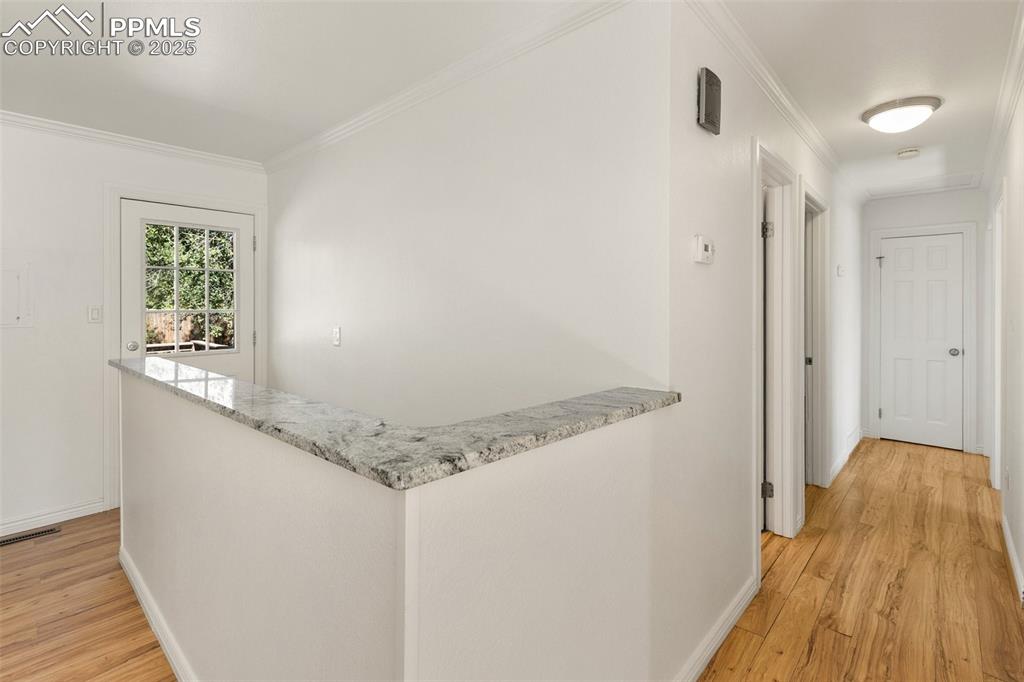 2518 Royalty Court Colorado Springs, CO 80904 - Photo 23 of 47 a view of a hallway with wooden floor and staircase