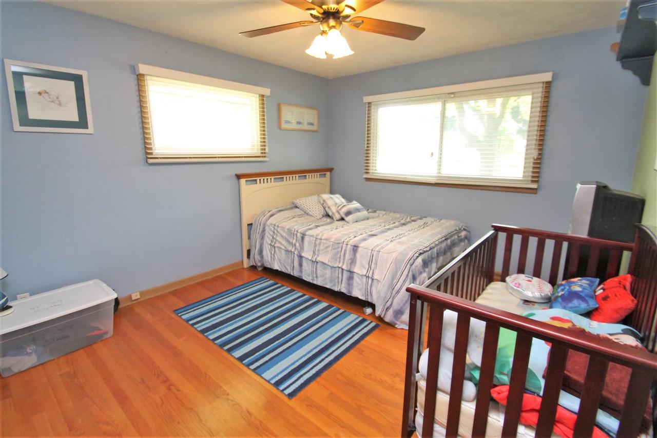 4118 Landstrom Road Rockford, IL 61114 - Photo 22 of 24 a bedroom with two beds and a chandelier
