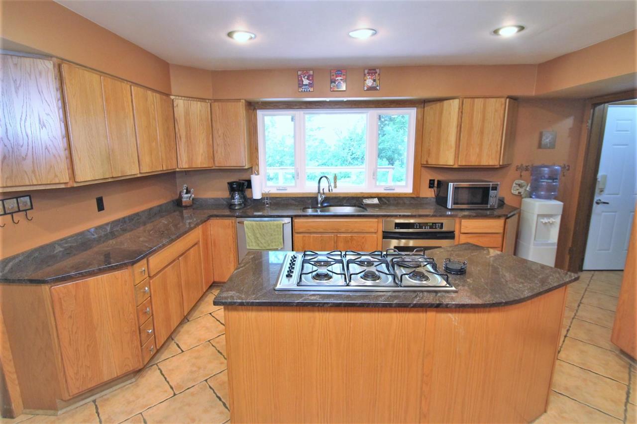 4118 Landstrom Road Rockford, IL 61114 - Photo 9 of 24 a large kitchen with stainless steel appliances granite countertop a refrigerator a sink dishwasher a stove and white countertops with wooden floor