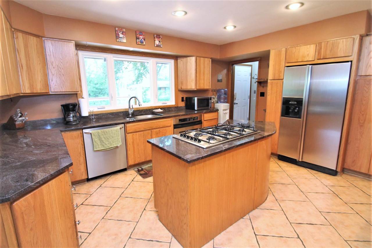 4118 Landstrom Road Rockford, IL 61114 - Photo 10 of 24 a kitchen with stainless steel appliances granite countertop a stove a sink and a refrigerator