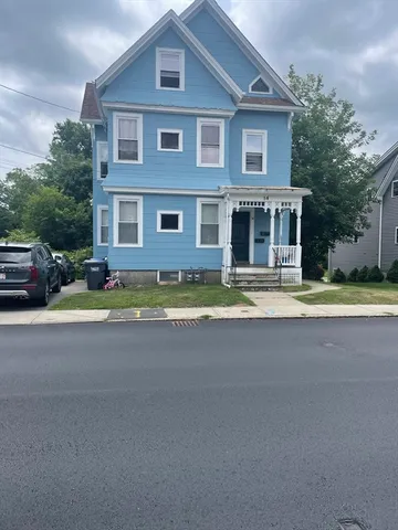 a front view of a house with a garden and yard