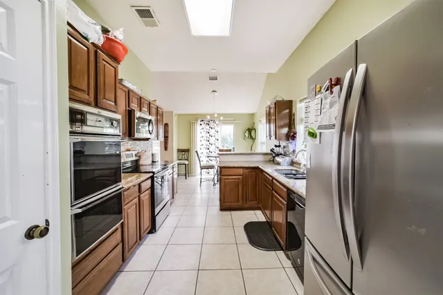 a kitchen with stainless steel appliances granite countertop a refrigerator and a stove