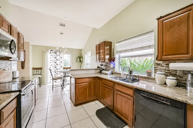 a kitchen with stainless steel appliances a sink counter space and a window