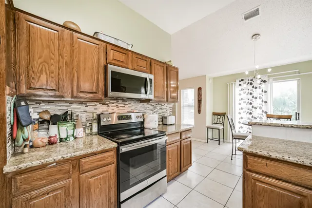 a kitchen with stainless steel appliances granite countertop a stove a sink and a microwave