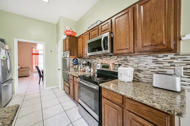 a kitchen with stainless steel appliances granite countertop a stove a sink and a microwave