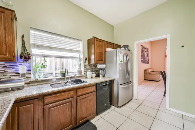 a kitchen with stainless steel appliances granite countertop a refrigerator and a sink