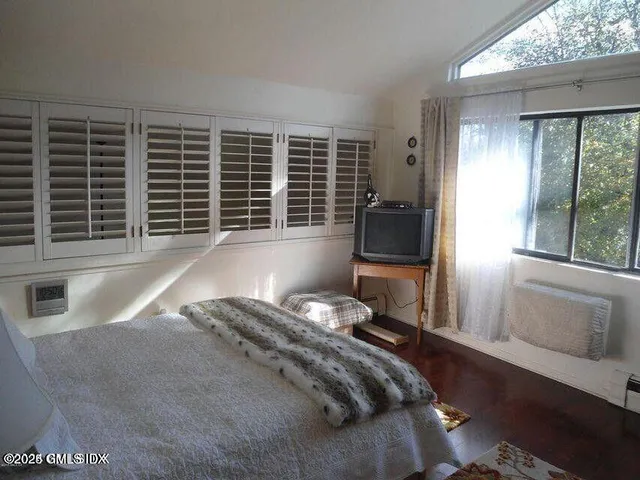 a view of a bedroom with furniture and a window