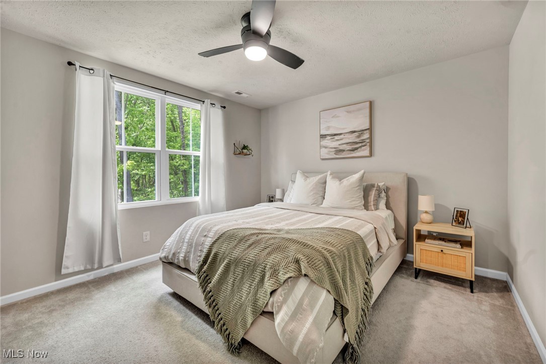 191 Raintree Lane Painesville, OH 44077 - Photo 22 of 35 Bedroom featuring light colored carpet, a textured ceiling, and a ceiling fan