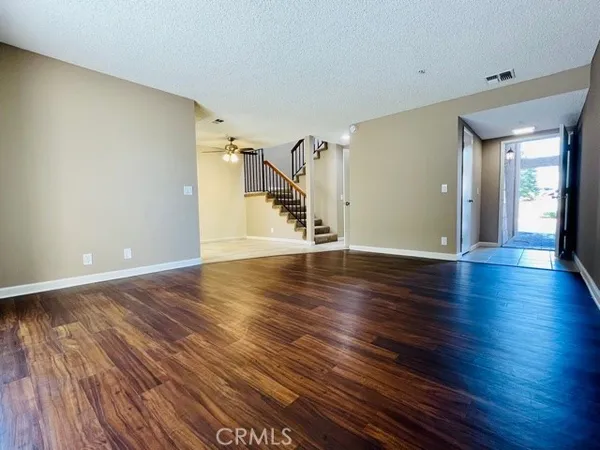 a view of empty room with wooden floor