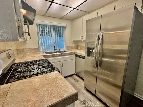 a kitchen with white cabinets and white appliances