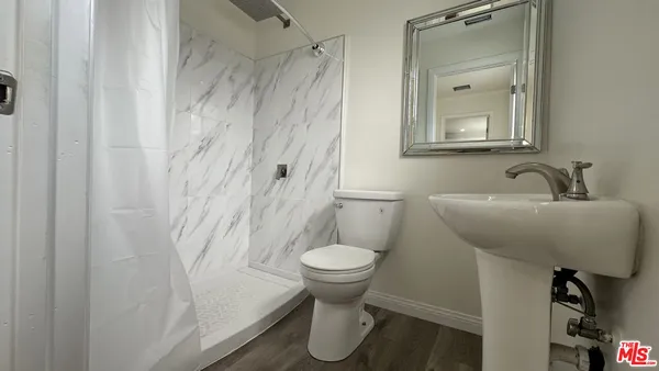 a bathroom with a toilet sink and a mirror