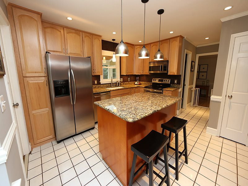 8320 Wheatstone Lane Raleigh, NC 27613 - Photo 7 of 23 Remodeled kitchen features granite, wood cabinets & SS appliances. Kitchen