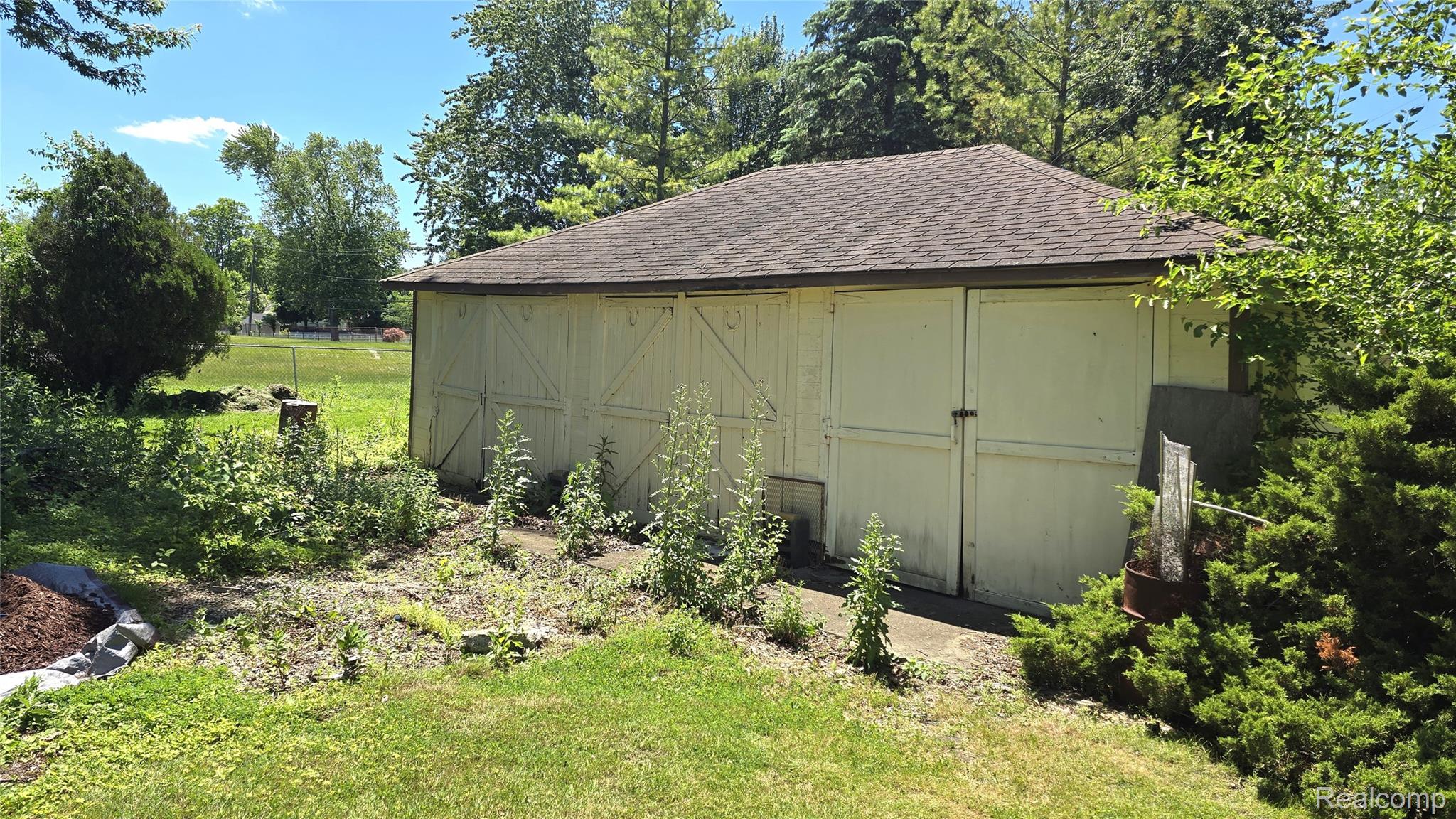 7993 Church Road Grosse Ile, MI 48138 - Photo 26 of 37 Detached garage structure with a shingled roof and multiple white panel doors