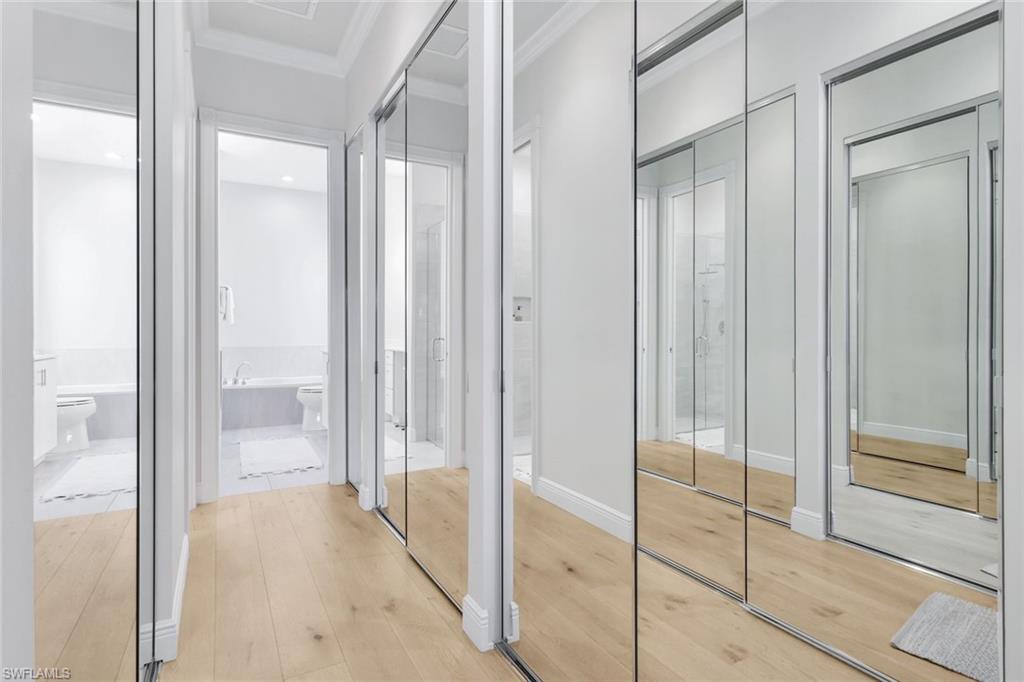 7063 Toscana Court Naples, FL 34114 - Photo 23 of 47 Corridor featuring wood-type flooring and ornamental molding