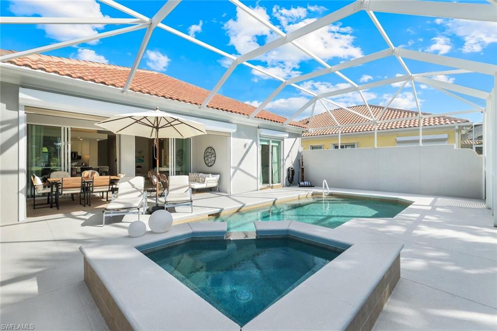 7063 Toscana Court Naples, FL 34114 - Photo 33 of 47 View of swimming pool featuring a sunroom, a patio area, glass enclosure, a pool with connected hot tub, and an outdoor living space