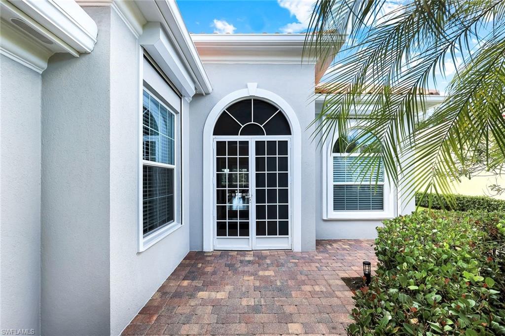 7063 Toscana Court Naples, FL 34114 - Photo 6 of 47 Entrance to property featuring stucco siding and a patio