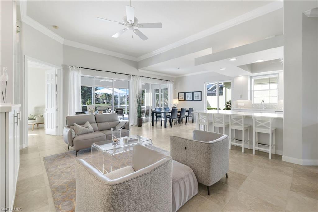 7063 Toscana Court Naples, FL 34114 - Photo 9 of 47 Living room with ornamental molding and a ceiling fan
