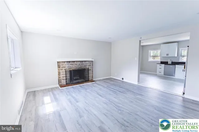 an empty room with wooden floor and fireplace