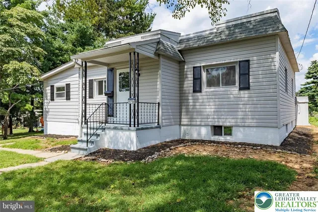 a view of a house with a yard and sitting area