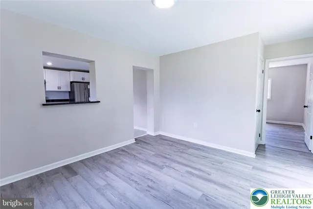 an empty room with wooden floor and mirror