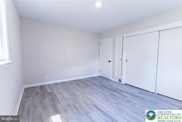 a view of an empty room with wooden floor