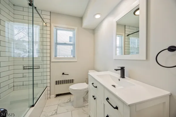a bathroom with a sink a toilet and shower
