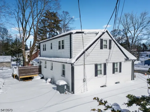 a white house that has tree in front of it