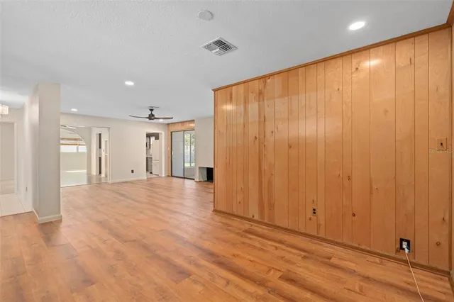 an empty room with a ceiling fan and window