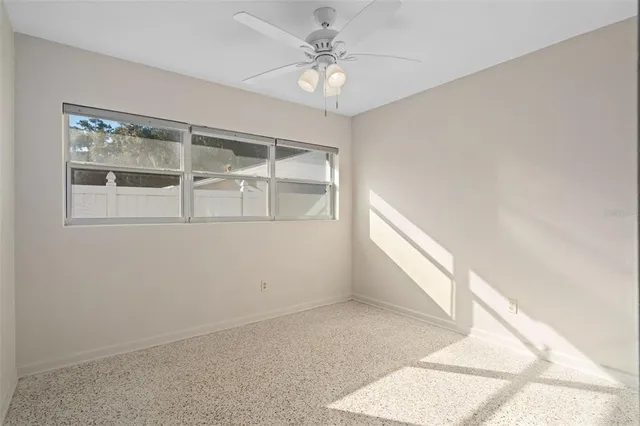 an empty room with windows and chandelier