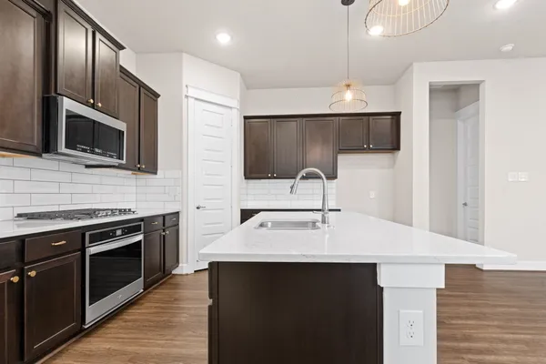 a kitchen with stainless steel appliances a sink stove and microwave