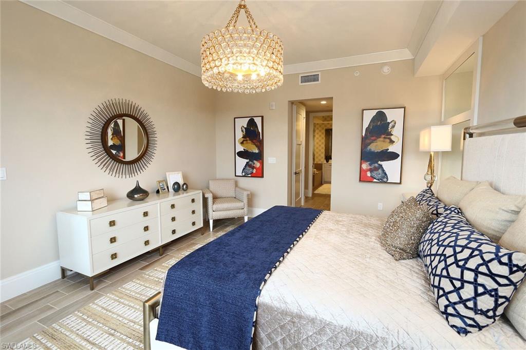 1135 3rd Avenue South, Unit 517 Naples, FL 34102 - Photo 13 of 35 a bedroom with furniture and a chandelier
