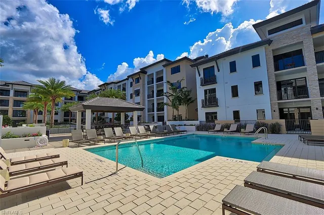 a view of a house with swimming pool and sitting area