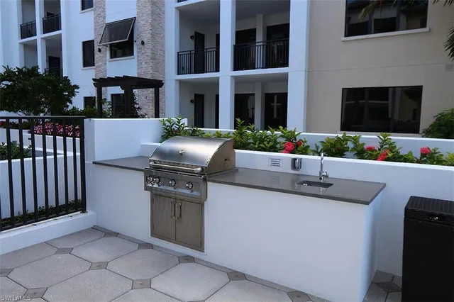 a kitchen with stainless steel appliances granite countertop a barbecue grill and a fireplace