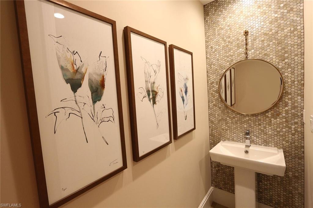 1135 3rd Avenue South, Unit 517 Naples, FL 34102 - Photo 10 of 35 a bathroom with a sink a mirror and a shower