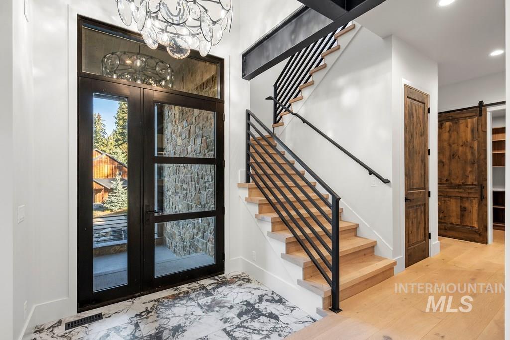 1008 Violet Way McCall, ID 83638 - Photo 21 of 37 Entrance foyer featuring a barn door, stairs, recessed lighting, french doors, and marble finish floors