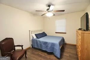 a bedroom with a bed tv and a window
