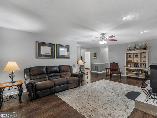 a living room with furniture a dining table and chairs with wooden floor