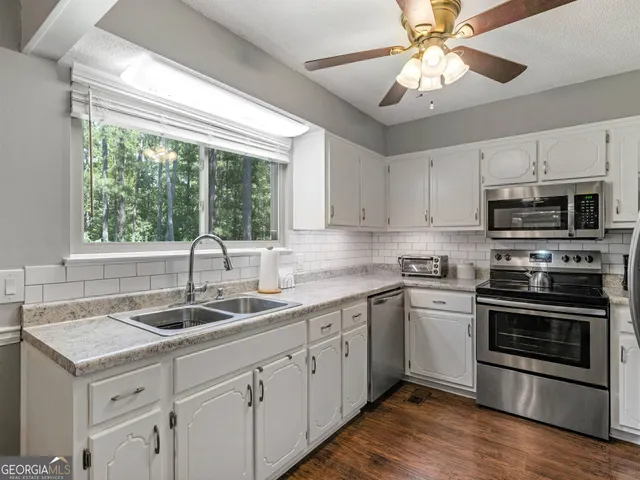 a kitchen with a sink appliances and cabinets