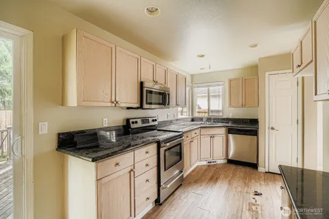 a kitchen with granite countertop a sink stove and cabinets