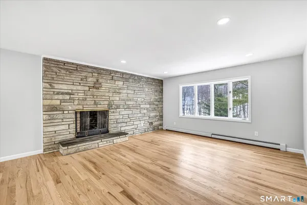 a view of empty room with wooden floor and fireplace