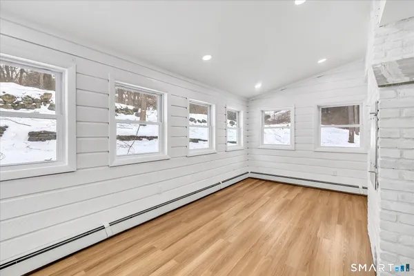 a view of an empty room with a window and wooden floor