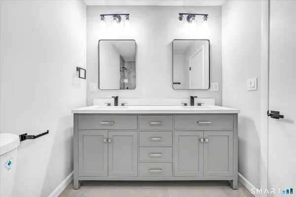 a bathroom with a double vanity sink and mirror