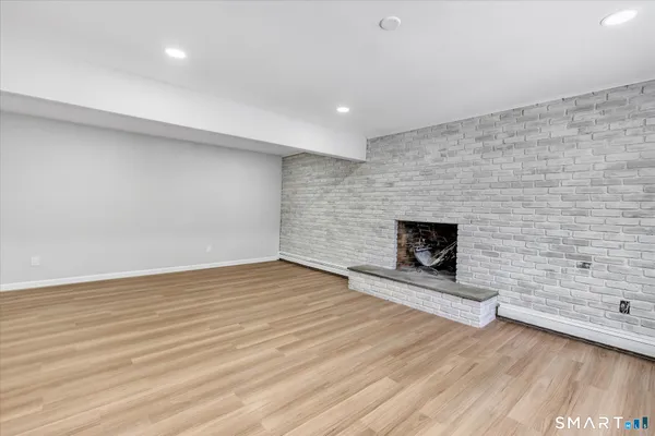 an empty room with wooden floor and fireplace