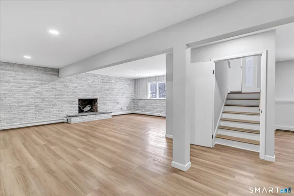 a view of empty room with wooden floor and fireplace