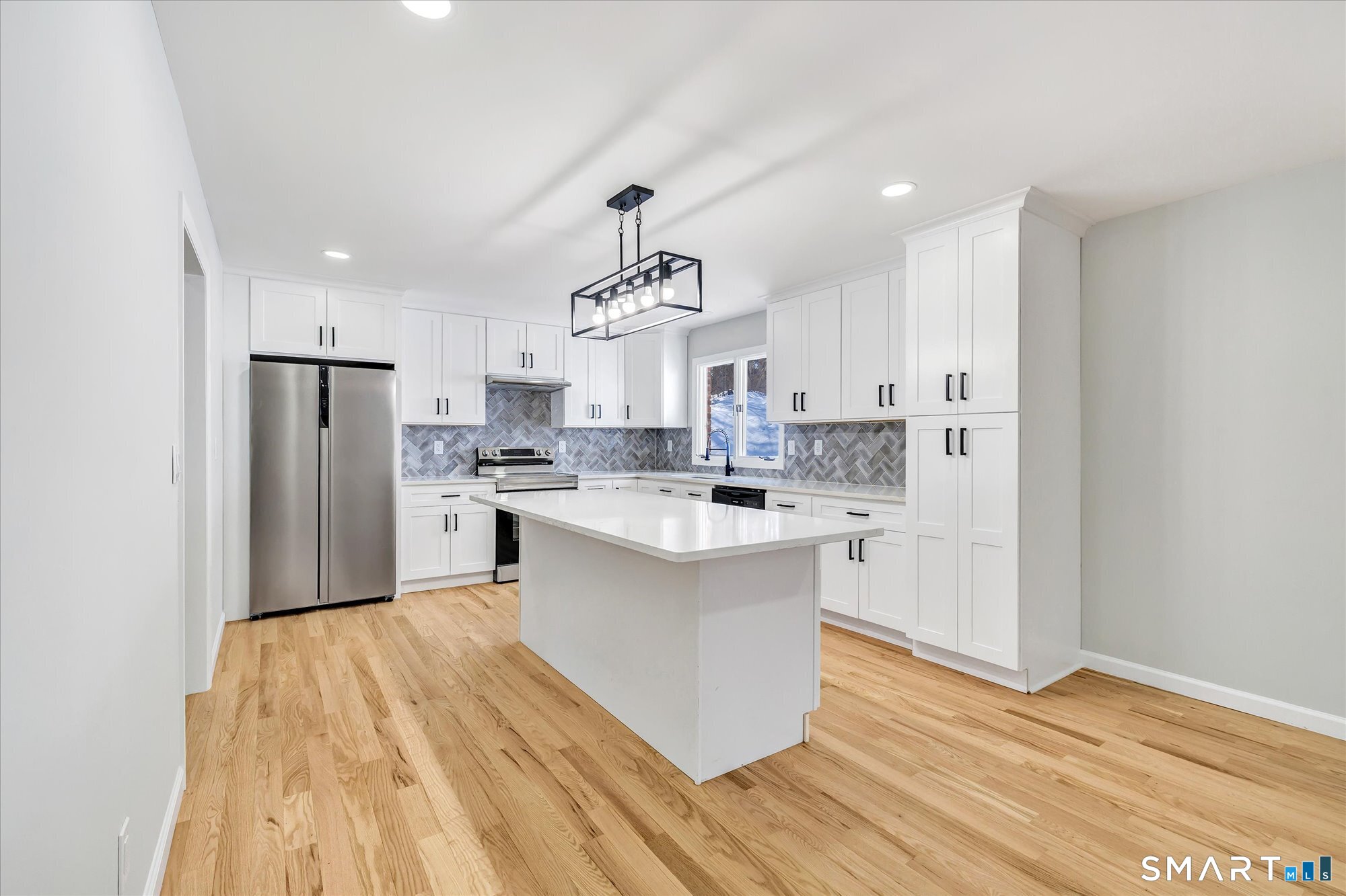 176 Strobel Road Trumbull, CT 06611 - Photo 4 of 39 a kitchen with stainless steel appliances a refrigerator a sink dishwasher a stove and white cabinets with wooden floor