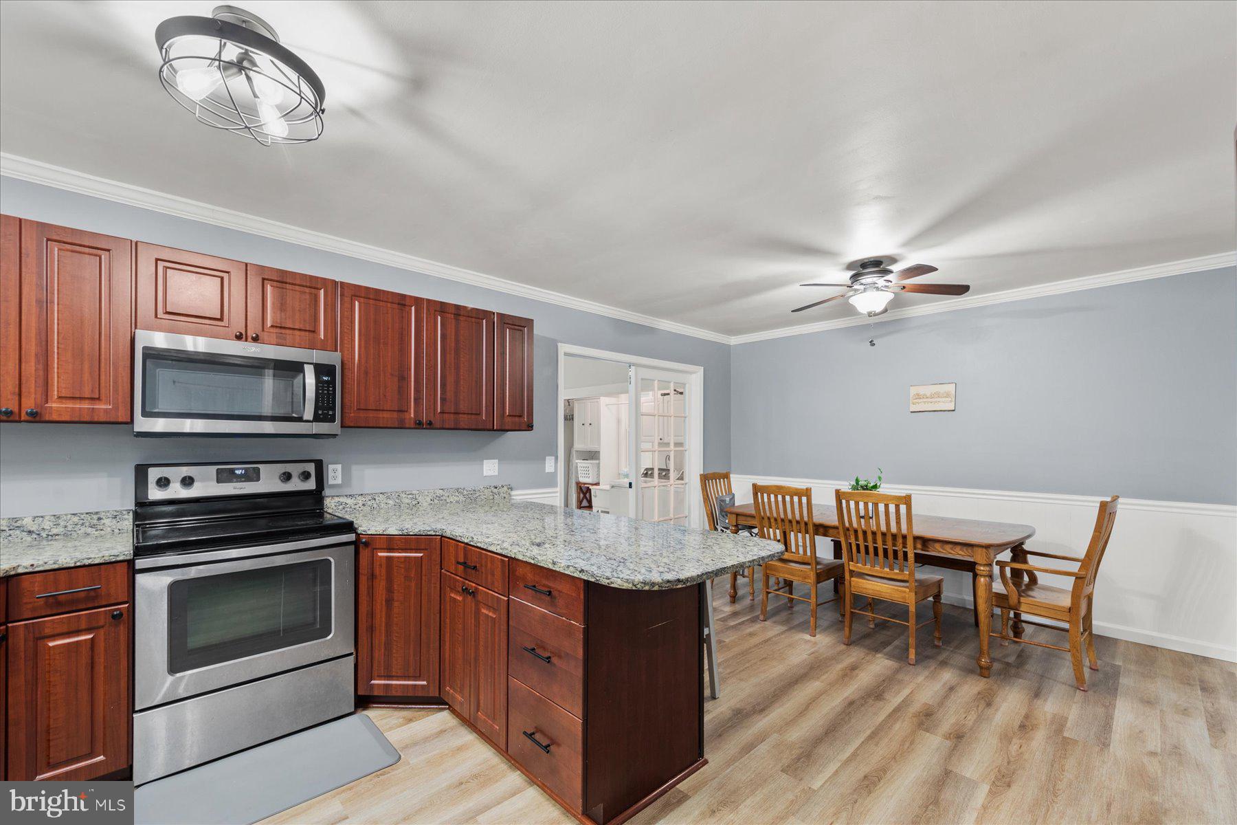 4 Poacher Berlin, MD 21811 - Photo 14 of 45 a kitchen with stainless steel appliances granite countertop a stove top oven a sink dishwasher a dining table and chairs with wooden floor