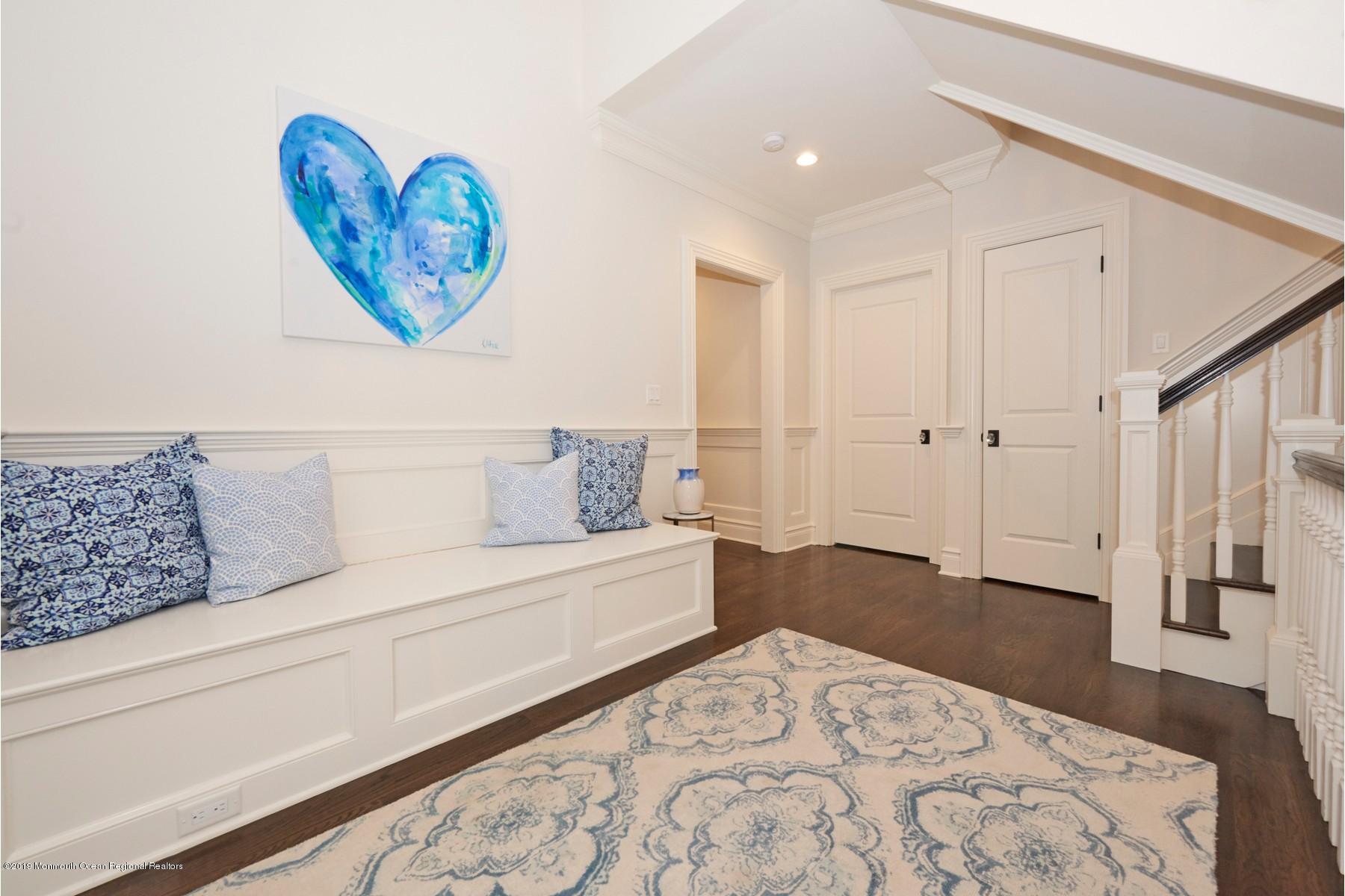 8 Heathcliff Road Rumson, NJ 07760 - Photo 35 of 46 a spacious bedroom with a bed and a chandelier